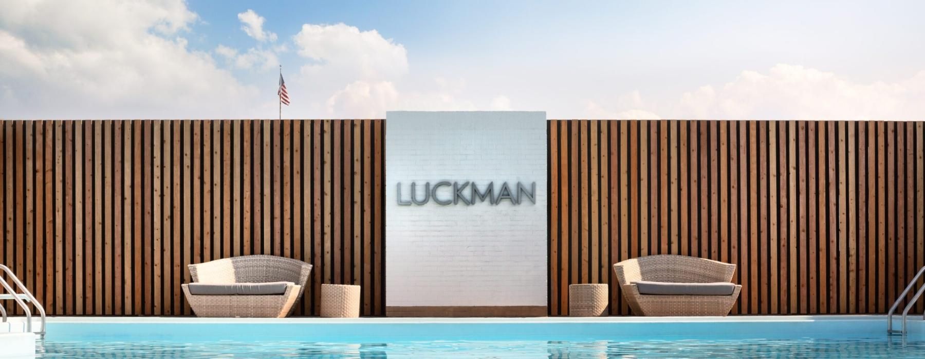 a pool with chairs and a wall with a sign on it