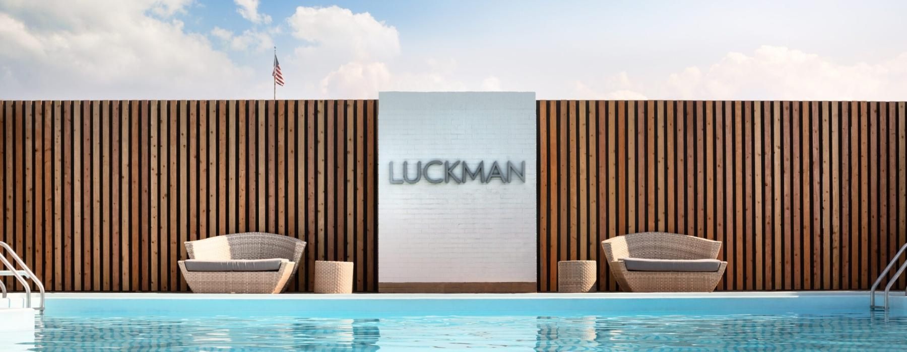 a pool with chairs and a wall with a sign on it